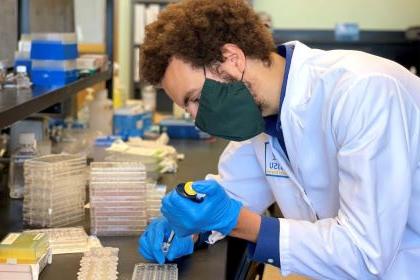 Masked individual in a lab coat.